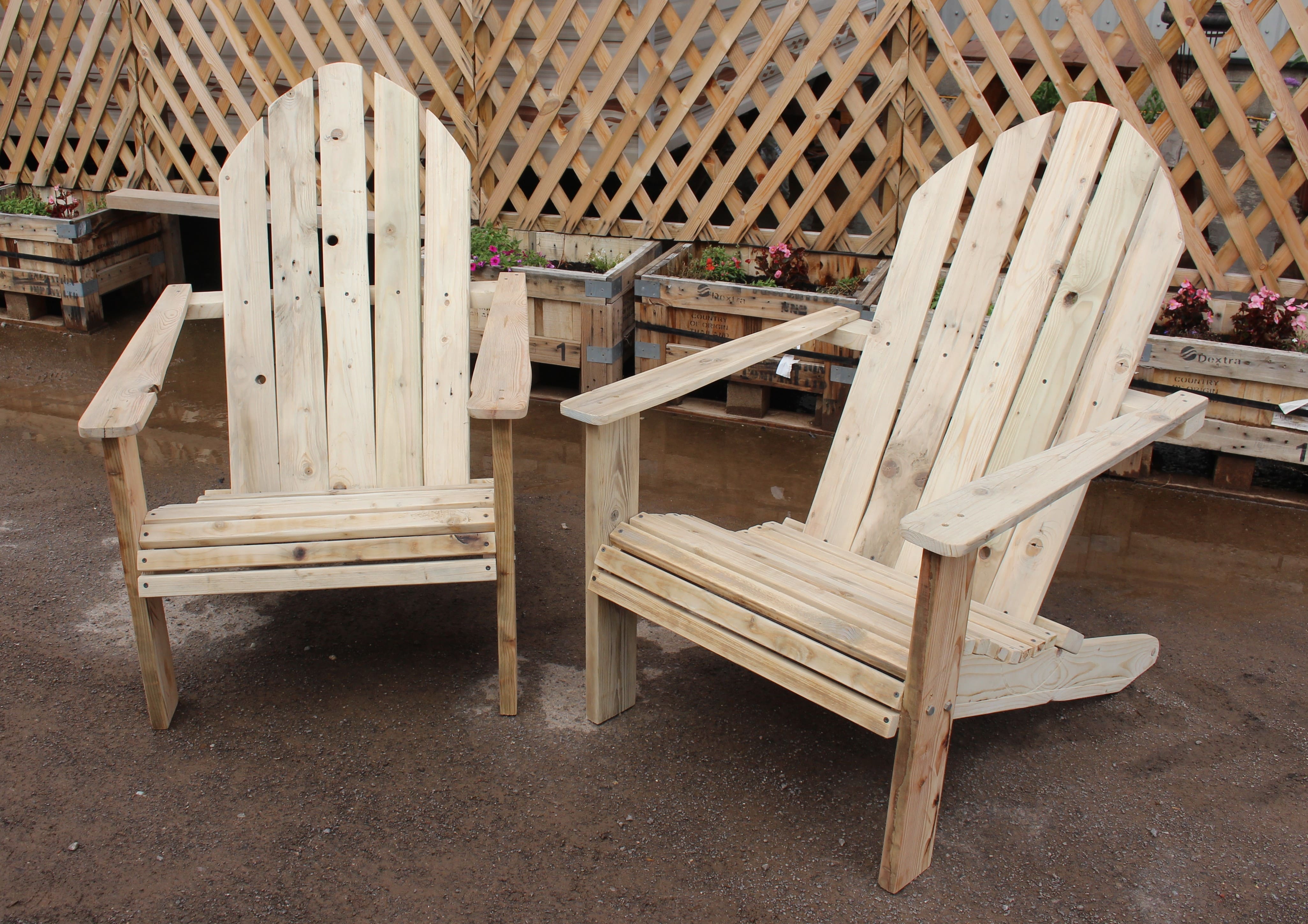 A pair of outdoor lounge chairs, with a tall back and the seat higher in the front than the back